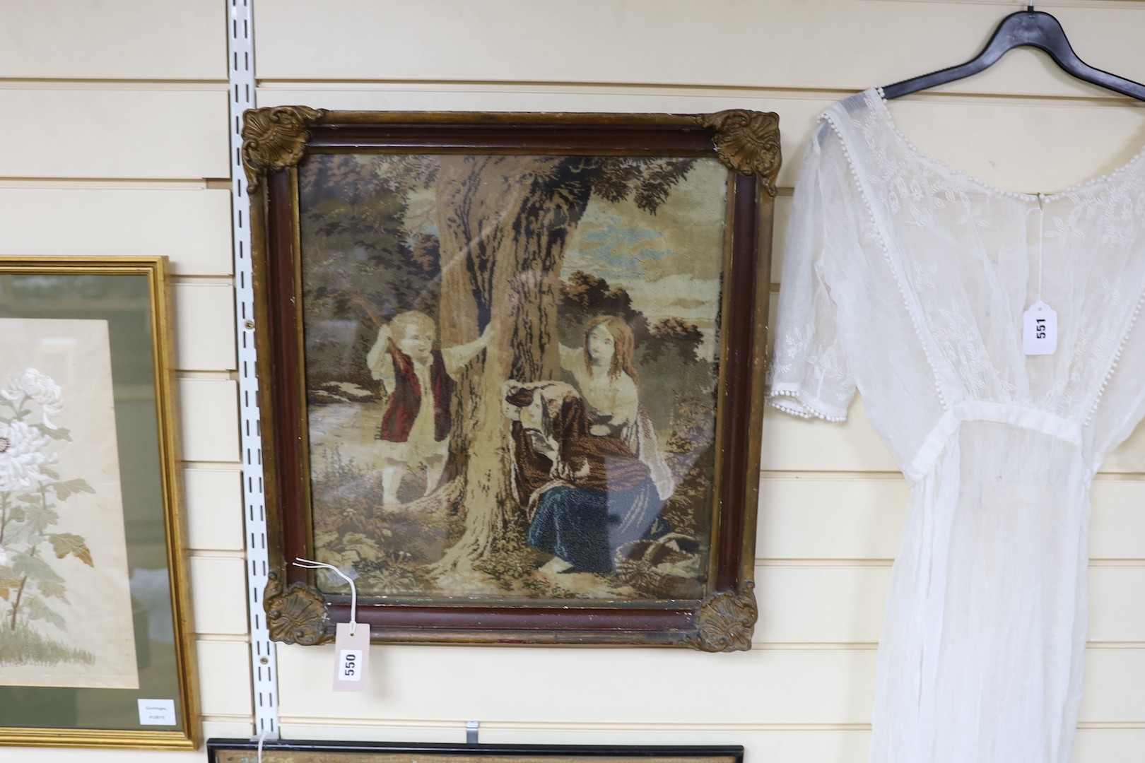 A framed Victorian woolwork panel depicting figures around a tree - 46 x 40cm